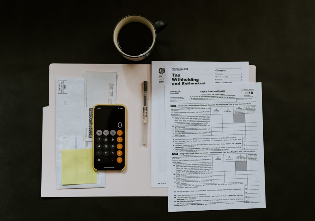 tax documents with a calculator and a coffee mug